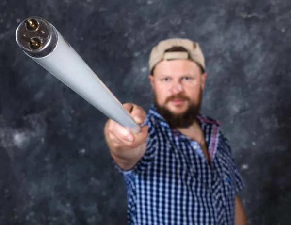 Vollbärtiger Mann in lässiger Kleidung mit Leuchtstofflampe sieht aus wie Stock — Stockfoto