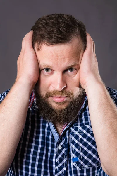 Frustrierter bärtiger Mann hält seinen Kopf an zwei Armen — Stockfoto