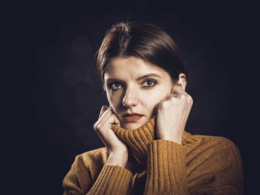 Süveter giymiş güzel bir kadının stüdyo portresi.