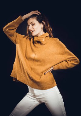 Süveter giymiş güzel bir kadının stüdyo portresi.