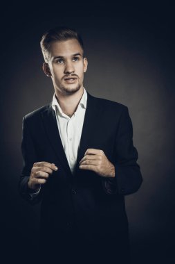 Takım elbiseli genç adam stüdyo resmi.