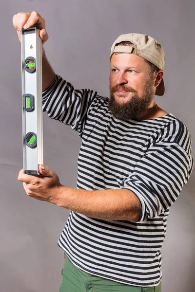 Fröhlicher bärtiger Handwerker mit ebenem und blankem Würfel-Studioporträt — Stockfoto