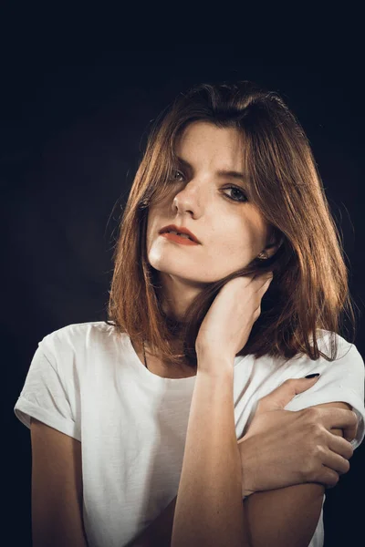 Studio portret van jonge mooie vrouw gekleed in een witte jeans en t-shirt — Stockfoto