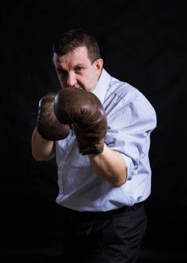 Orta yaşlı, boks eldivenli, sert bir adam.