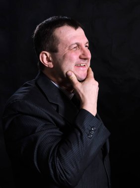 Orta yaşlı, takım elbiseli, sağlam bir adam.