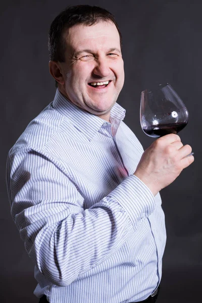 Μεσήλικας χαρούμενος άντρας ντυμένος με πουκάμισο με ένα ποτήρι κρασί — Φωτογραφία Αρχείου