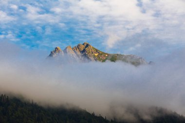 Kafkasya dağlarının manzarası, dağların tepesinde bulutlar.