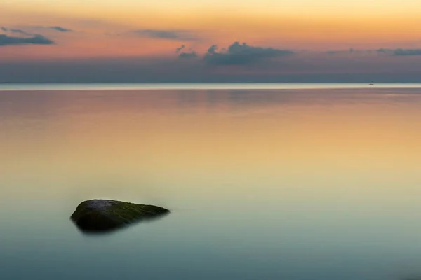 Cena bonita com mar calmo e pedras ao pôr do sol — Fotografia de Stock