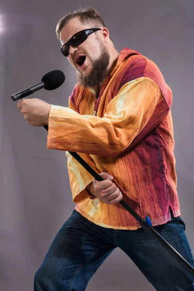 Vousatý emocionální rockový zpěvák s portrétem mikrofonu studia. — Stock fotografie