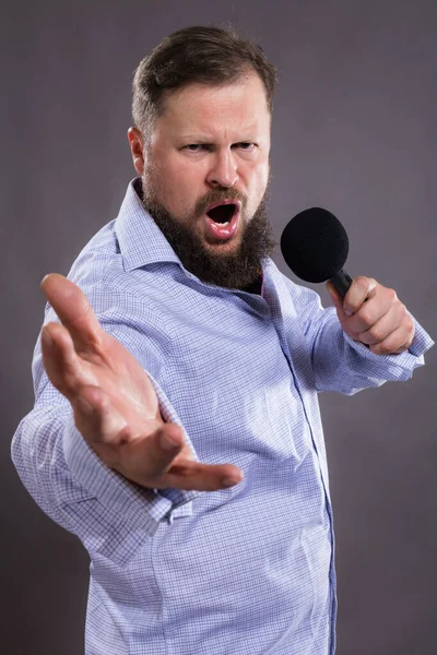 Bearded penyanyi emosional dengan mikrofon mengenakan kemeja — Stok Foto