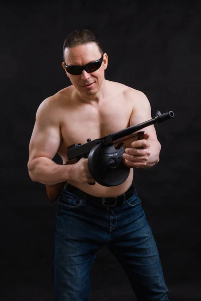 Felnőtt férfi napszemüvegben és meztelen törzs Tommy pisztollyal — Stock Fotó