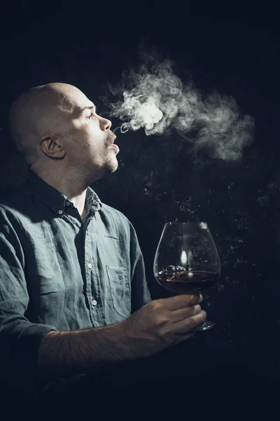 Solider Glatzkopf im Hemd mit einem Glas Whisky und Qualm — Stockfoto