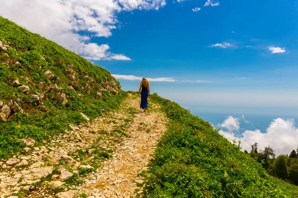 Paisaje de montaña en las montañas del Cáucaso con la mujer caminando por la pista de la carretera —  Fotos de Stock