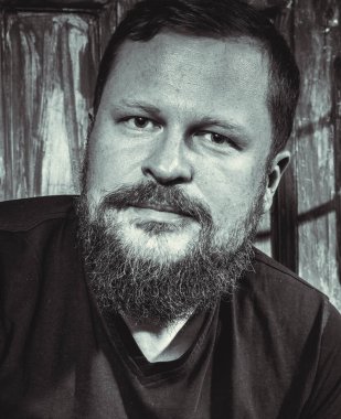 Olgun sakallı adam klasik kapının arkasında oturuyor.