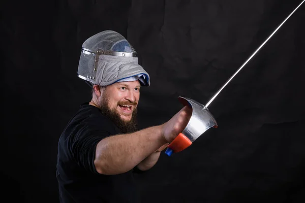 Homem barbudo de meia idade com epee e capacete — Fotografia de Stock