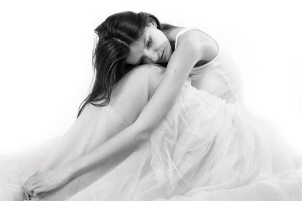 Young beautiful woman sitting in tulle dress monochrome portrait