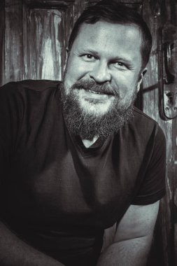 Olgun sakallı adam klasik kapının arkasında oturuyor.