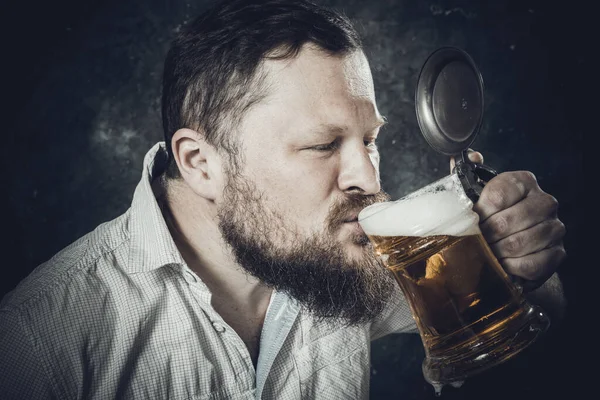 Matured lachende man met baard in shirt met bier mok — Stockfoto