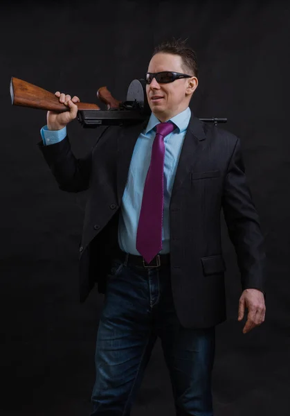 Volwassen gangster in zonnebril gekleed in pak met tommy gun — Stockfoto