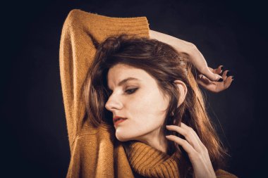 Süveter giymiş güzel bir kadının stüdyo portresi.