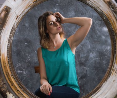 Güzel genç bir kadın aynaya bakıyor.