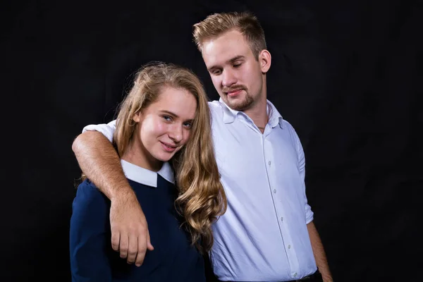 Young beautiful couple studio portrait on black background. — Stock Photo, Image