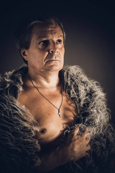 Solid middle-aged man in a fur mantle