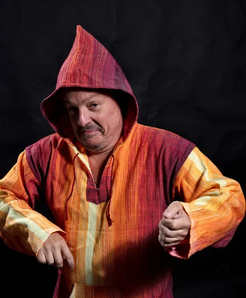 Middle aged man in bright orange clothe dancing — Stock Photo, Image