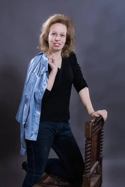 Cheerful 40 years old woman dressed in blue jeans and azure jacket — Stock Photo, Image