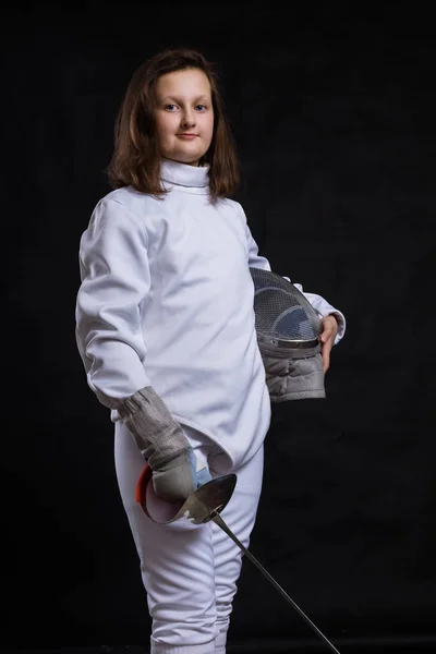 Adolescente esgrima chica vestida en uniforme con epee y casco —  Fotos de Stock