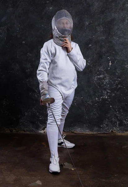 Tiener meisje fencer gekleed in uniform met epee en helm — Stockfoto