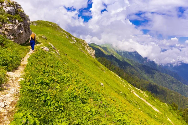 Paisaje de montaña en las montañas del Cáucaso con la mujer caminando por la pista de la carretera —  Fotos de Stock