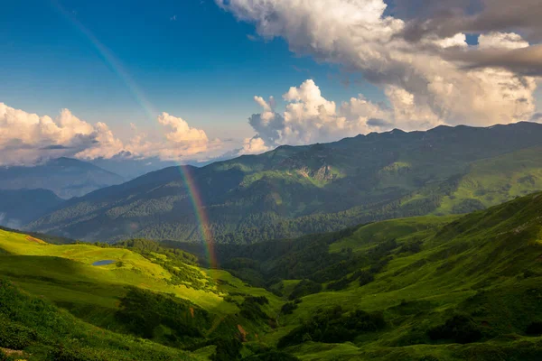 Hermoso paisaje montañoso en las montañas del Cáucaso con cielo azul, nubes y arco iris —  Fotos de Stock