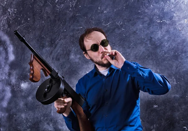 Dojrzały mężczyzna w okularach z pistoletem Tommy 'ego — Zdjęcie stockowe