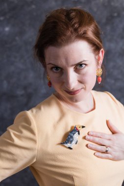 Bej elbise giymiş orta yaşlı neşeli bir kadın stüdyo portresi.