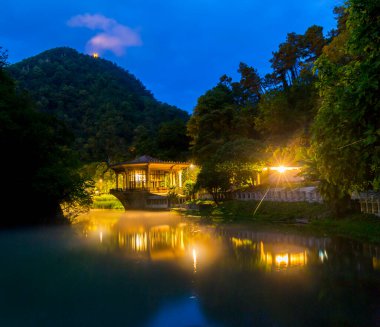 Suyun üzerinde eski bir pavyon ile güzel bir gece manzarası
