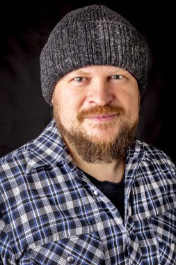 Katı sakallı, yün şapkalı bir adam.