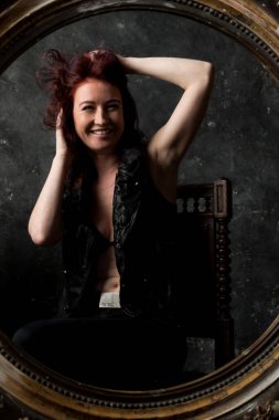 Güzel genç bir kadın aynaya bakıyor.