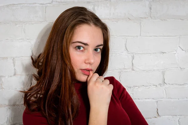 Jonge mooie vrouw portret op witte baksteen muur achtergrond. — Stockfoto