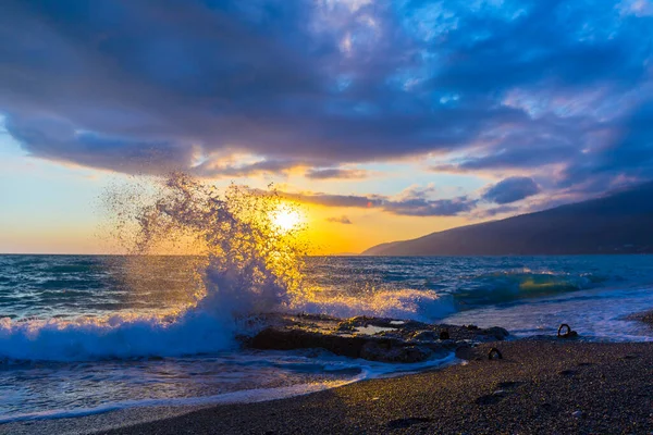 Gün batımında dalgalarla güzel bir kıyı sahnesi