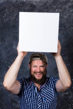 Logon için beyaz kübü olan tişörtlü neşeli sakallı adam.