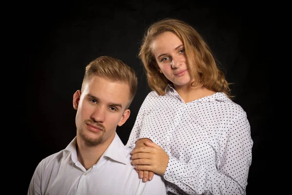 Young beautiful couple studio portrait on black background. — Stock Photo, Image