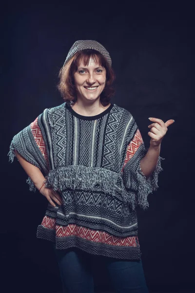 Χαρούμενη 40χρονη γυναίκα ντυμένη με τζιν και poncho studio πορτρέτο — Φωτογραφία Αρχείου