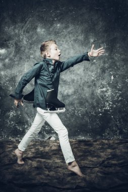 Beyaz kot ve mavi gömlek giymiş genç bir artistik patenci.