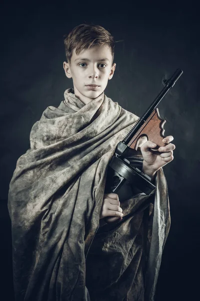 Tenn jongen gekleed in camouflage badjas met een pistool spelen soldaat — Stockfoto