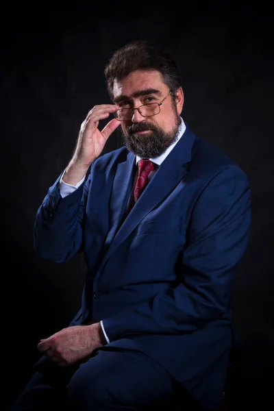 Uomo d'affari maturo vestito in abito blu con cravatta rossa studio ritratto. — Foto Stock