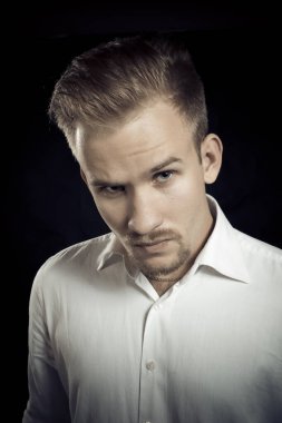 Beyaz gömlekli genç adam stüdyo resmi.