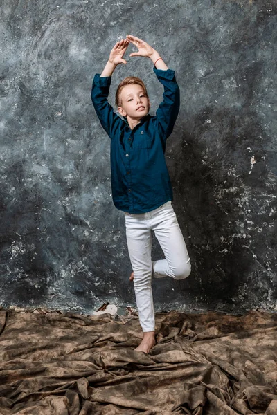 Jovem dançarina vestida com jeans brancos e camisa azul fazendo figuras retrato estúdio — Fotografia de Stock