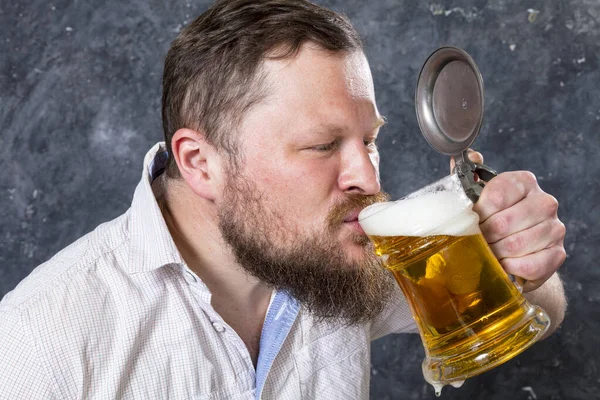 Matured lachende man met baard in shirt met bier mok — Stockfoto