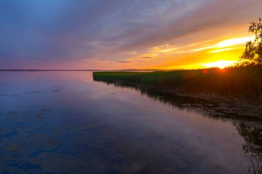 Gölün üzerinde güzel renkli gün batımı yaz manzarası.